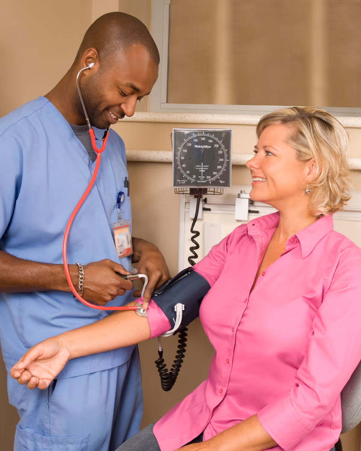 A community nurse checking a participant's blood pressure during a home visit