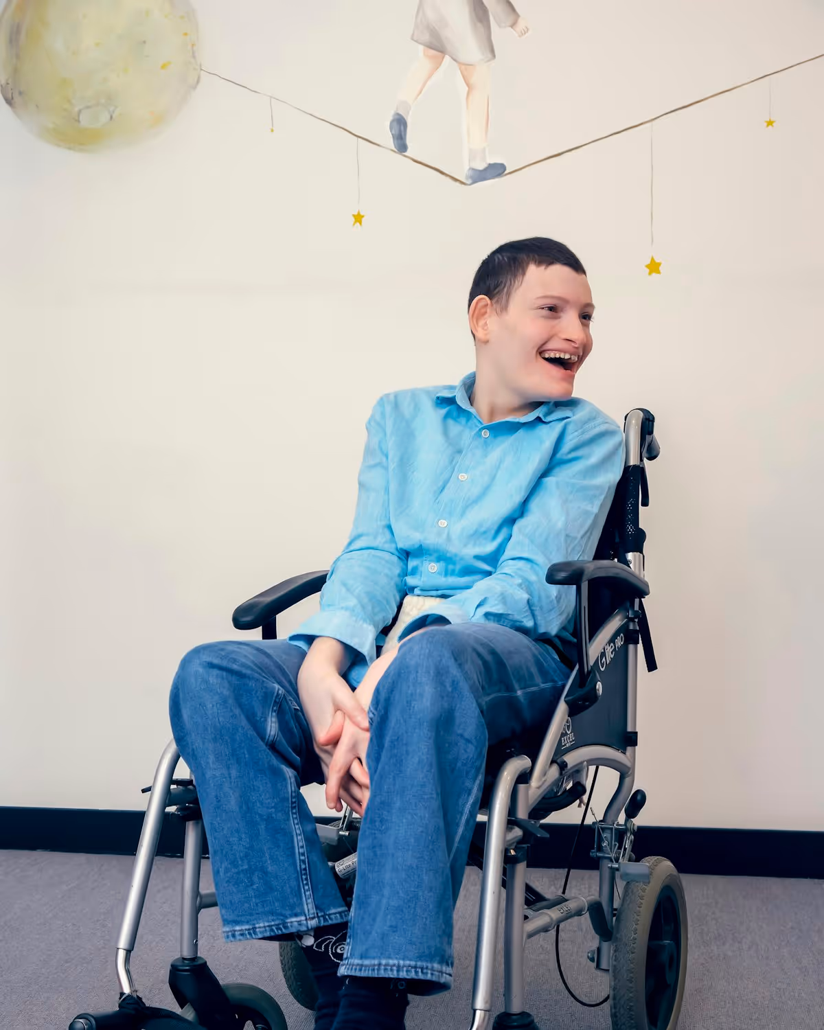 A young man using a wheelchair smiling warmly at home